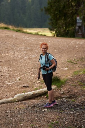 Foto de Mujer con mochila senderismo en las montañas en un sendero - Imagen libre de derechos