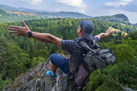 Téléchargez les photos : Randonneur homme reposant sur le sommet de la montagne avec une belle vue - en image libre de droit