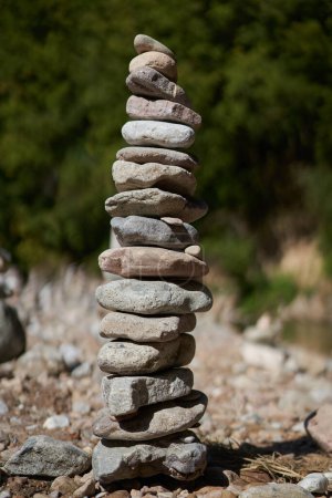 Photo for River pebbles and stones arranged in tower structures on the shore - Royalty Free Image