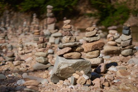 Photo for River pebbles and stones arranged in tower structures on the shore - Royalty Free Image