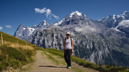 Téléchargez les photos : Jeune randonneuse sur un sentier pédestre dans les Alpes suisses - en image libre de droit
