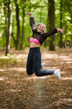 Photo for Young dancer woman making some dance moves in the forest, candid shot - Royalty Free Image