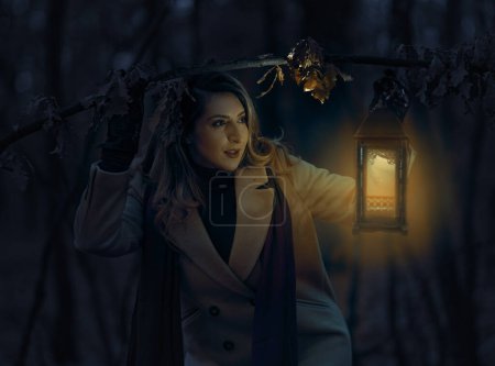 Foto de Mujer con una linterna en un bosque espeluznante por la noche - Imagen libre de derechos