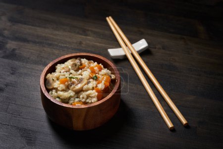 Foto de Receta tailandesa de arroz hervido y frito con champiñones y hierbas y verduras en un tazón rústico - Imagen libre de derechos