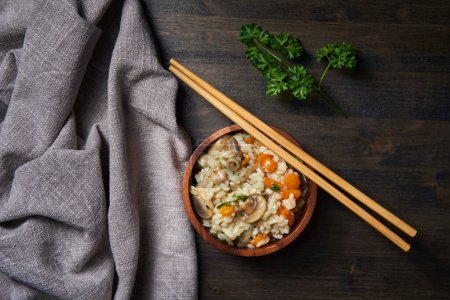Photo for Thai recipe of boiled and fried rice with mushrooms and herbs and veggies in a rustic bowl - Royalty Free Image
