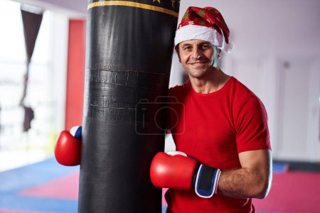 Téléchargez les photos : Fit Père Noël vous invitant à passer les vacances d'hiver de formation dans la salle de gym - en image libre de droit