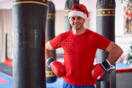 Téléchargez les photos : Fit Père Noël vous invitant à passer les vacances d'hiver de formation dans la salle de gym - en image libre de droit