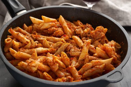 Photo for Minced meat and penne pasta in italian tomato sauce in a wok, closeup shot - Royalty Free Image