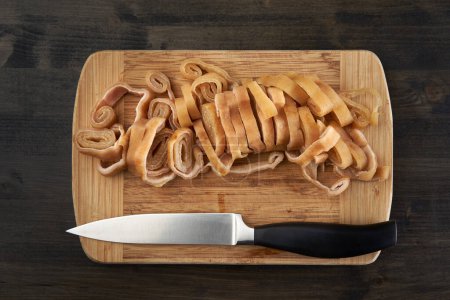 Téléchargez les photos : Tranchés délicieuse peau de porc frite sur une planche de bois - en image libre de droit