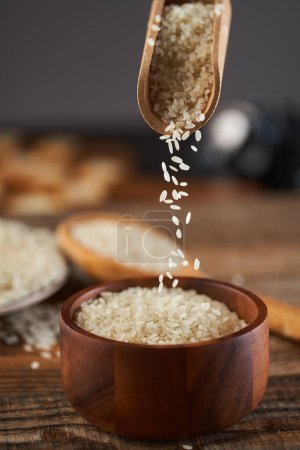 Photo for Asian rice on a wooden board in closeup, uncooked, raw - Royalty Free Image