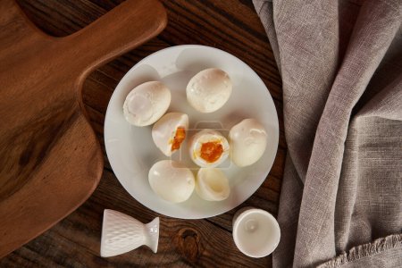 Photo for Soft boiled eggs on a plate on a wooden board, flat lay studio shot - Royalty Free Image