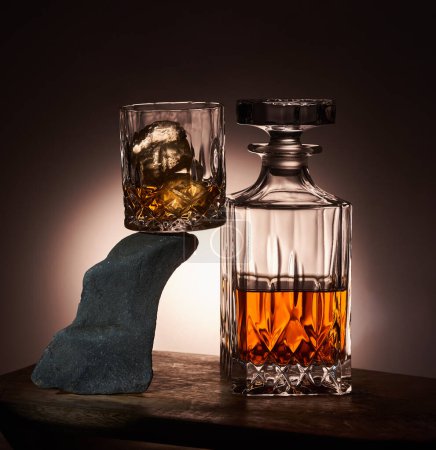 Photo for Glass and bottle of scotch, the glass is standing on a beautifully shaped rock - Royalty Free Image
