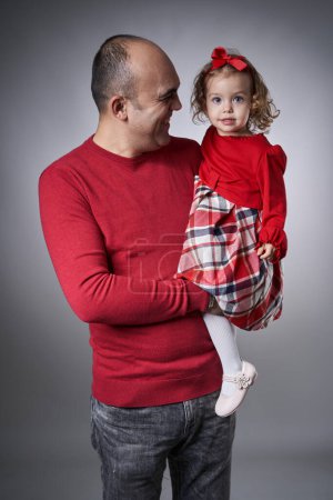 Téléchargez les photos : Heureux père et tout-petit fille portrait sur fond gris, studio shot - en image libre de droit