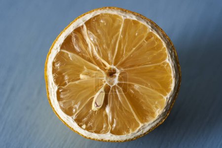 Photo for Dried sliced half lemon on a blue wooden board, closeup shot - Royalty Free Image