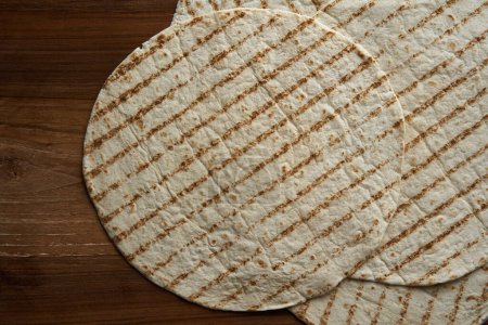 Téléchargez les photos : Plan plat de tortilla enveloppée sur une planche de noyer en bois - en image libre de droit