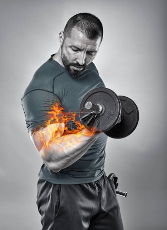 Téléchargez les photos : Image conceptuelle d'un entraîneur de fitness brûlant le muscle biceps en faisant des boucles avec haltère - en image libre de droit