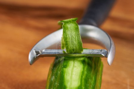 Téléchargez les photos : Eplucher un concombre, en gros plan sur le couteau éplucheur - en image libre de droit