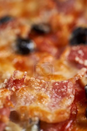 Foto de Macro inyectado en una pizza con parmesano derretido que cubre ingredientes como aceitunas, pepperoni o jamón - Imagen libre de derechos