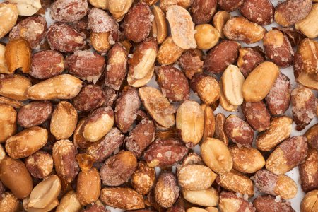 Téléchargez les photos : Cacahuètes salées cuites au four en peau rouge, gros plan en studio - en image libre de droit
