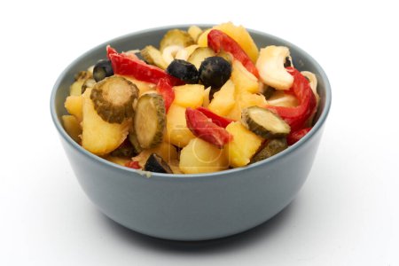 Téléchargez les photos : Salade d'olives marinées, cornichons et poivrons avec pommes de terre dans un bol, isolé sur fond blanc - en image libre de droit