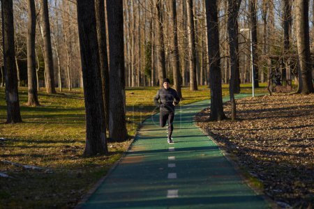 Photo for Mature athlete running in the park in a cold sunny winter day - Royalty Free Image