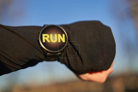 Foto de Hombre con un reloj inteligente para correr, con un mensaje positivo en la pantalla, listo para entrenar - Imagen libre de derechos