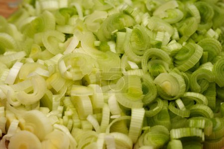 Photo for Closeup of fresh leek chopped on a wooden board for a recipe - Royalty Free Image