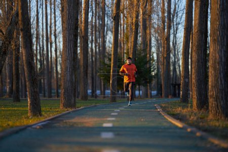 Photo for Athletic man joggin in park at sunset in a cold winter day - Royalty Free Image