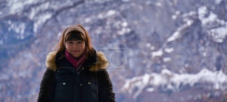 Foto de Mujer joven turista en abrigo de invierno con montañas en el fondo - Imagen libre de derechos