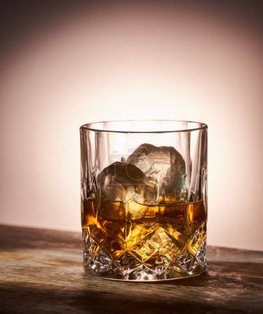 Photo for Closeup of a glass of scotch with ice cubes on a wooden ledge - Royalty Free Image