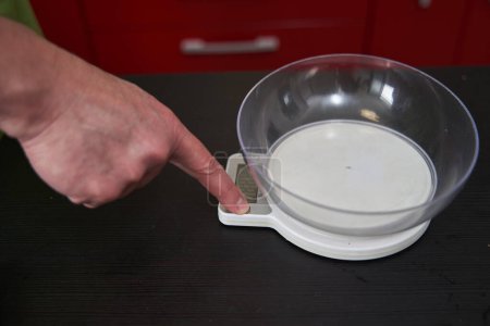 Photo for Chef's hand setting up the kitchen scale for use - Royalty Free Image