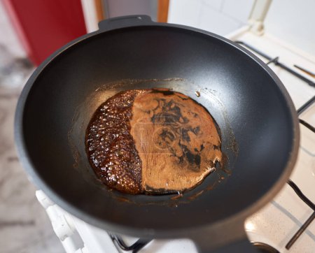 Caramelizing muscovado sugar in a large wok on a stove