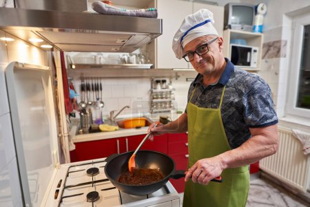Téléchargez les photos : Homme caramélisant le sucre muscovado dans un grand wok sur un poêle - en image libre de droit