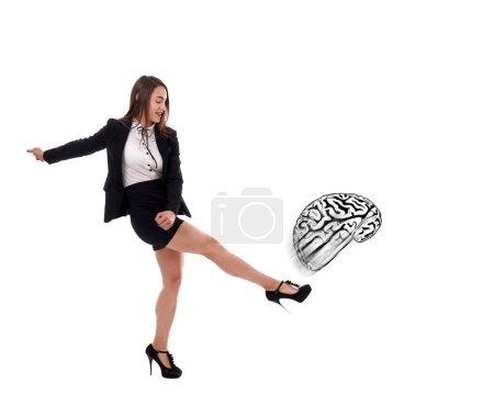 Photo for Young businesswoman furiously kicking the brain isolated on white background, concept of not thinking when doing business - Royalty Free Image