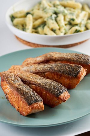 Téléchargez les photos : Steak de saumon frit avec garniture de penne rigate au fromage bleu et brocoli de côté - en image libre de droit