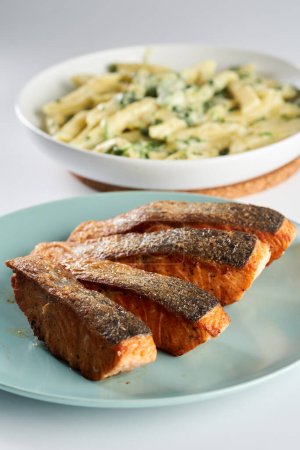Téléchargez les photos : Steak de saumon frit avec garniture de penne rigate au fromage bleu et brocoli de côté - en image libre de droit