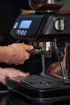 Téléchargez les photos : Homme barista à l'aide d'outils professionnels pour la fabrication de café expresso de haute qualité, gros plan - en image libre de droit