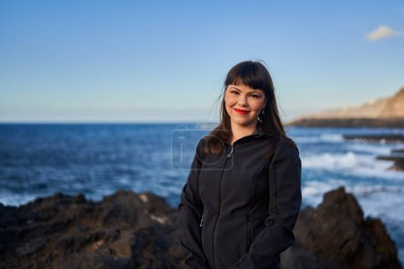 Téléchargez les photos : Portrait d'une belle jeune femme debout au bord de l'océan aux îles Canaries, Vacances en Ténérife - en image libre de droit