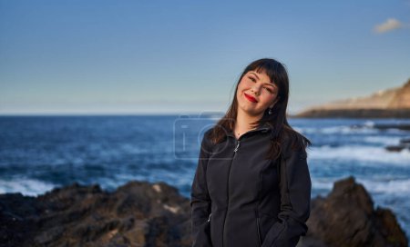 Foto de Retrato de una hermosa joven parada junto al mar en las Islas Canarias, Vacaciones en Tenerife - Imagen libre de derechos