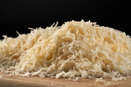Téléchargez les photos : Parmesan block grated in detailed closeup over black background - en image libre de droit