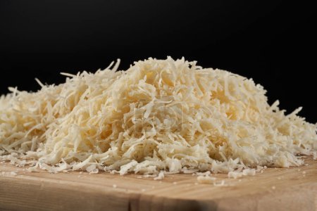 Photo for Parmesan block grated in detailed closeup over black background - Royalty Free Image