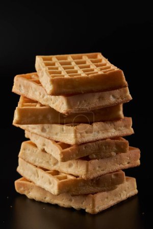 Photo for A pile of belgian waffles in closeup on black background - Royalty Free Image