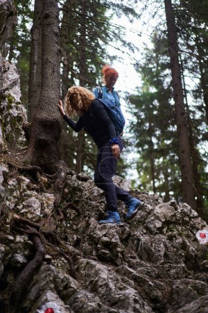 Téléchargez les photos : Femmes avec sacs à dos randonnées en montagne au début du printemps - en image libre de droit