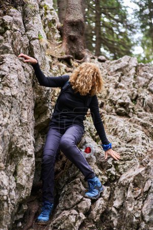 Téléchargez les photos : Randonneuse avec sac à dos randonnée sur sentier en montagne - en image libre de droit