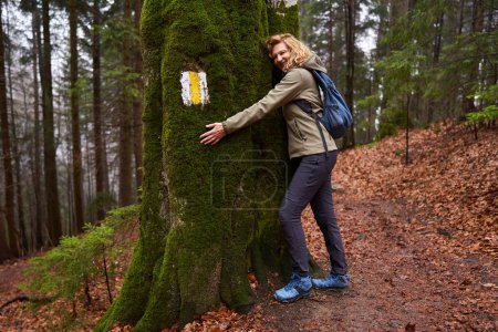 Photo for Woman with backpack hiking on a rainy day in the mountains - Royalty Free Image