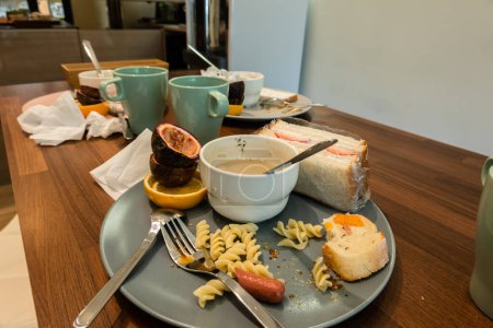 Foto de Plato sucio y taza con sobras de comida en la mesa - Imagen libre de derechos