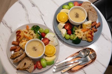 Téléchargez les photos : Copieux petit déjeuner avec du pain et des fruits dans une assiette à la maison - en image libre de droit