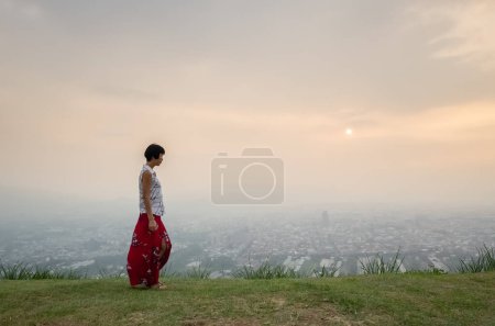 Foto de Viajar asiático maduro mujer caminar en un colina cerca de un ciudad - Imagen libre de derechos