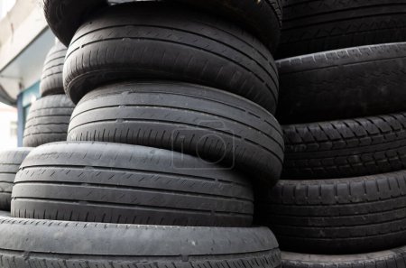 Téléchargez les photos : Vieux pneus de voiture d'occasion empilés en tas dans la journée - en image libre de droit