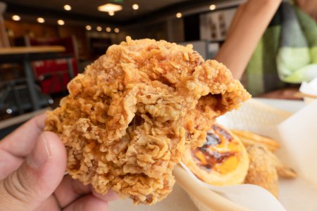 Téléchargez les photos : Tenir le poulet frit à portée de main dans un restaurant de restauration rapide - en image libre de droit